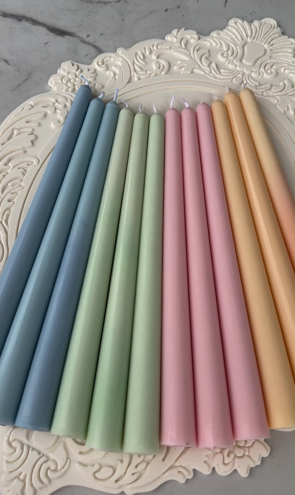 Velas cónicas en tonos pastel: azul, verde, rosa y durazno